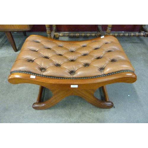 114 - A mahogany and tan leather saddle stool