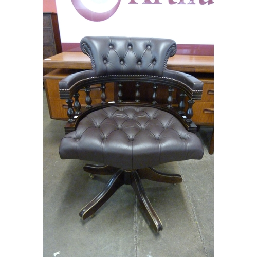 115 - A mahogany and leather revolving Captain's desk chair