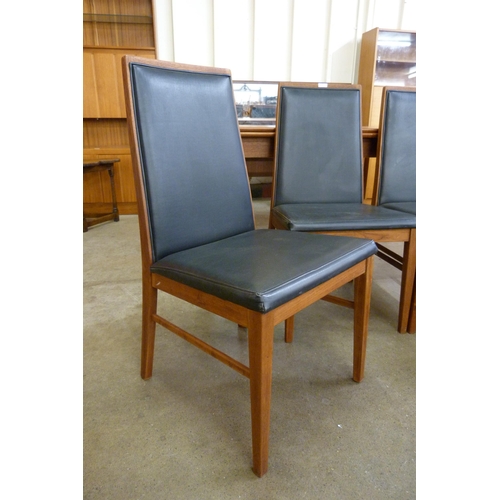 12 - A set of four Danish Dyrlund teak and black vinyl dining chairs