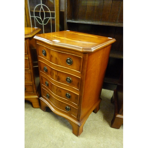 140 - A pair of small yew wood serpentine chests of drawers