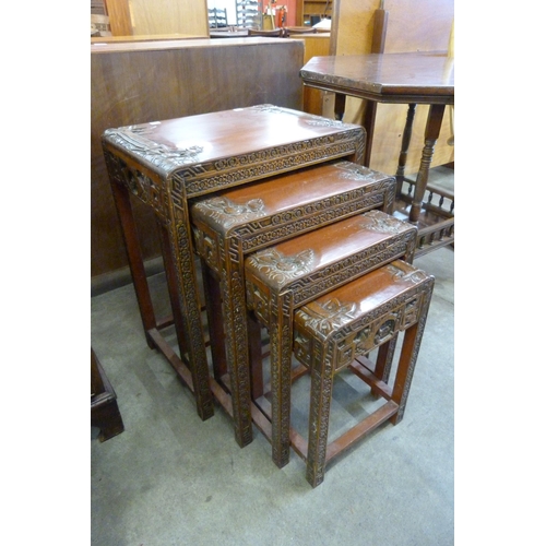 147 - An oriental carved hardwood nest of quartetto tables