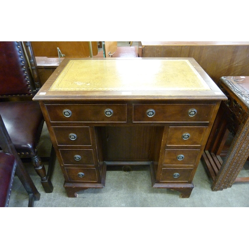 149 - A George I style mahogany and tan leather topped kneehole desk