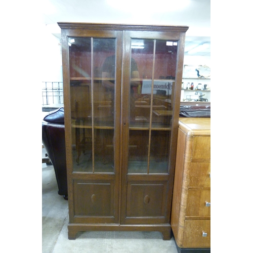 166 - An early 20th Century carved oak two door bookcase