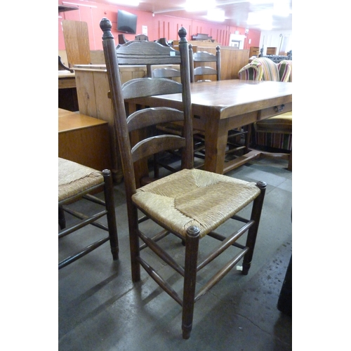 182 - A French elm farmhouse single drawer table and four ladderback chairs