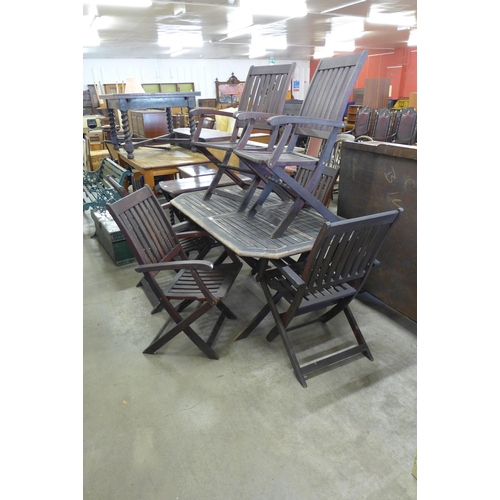 595 - A teak garden table and six folding chairs