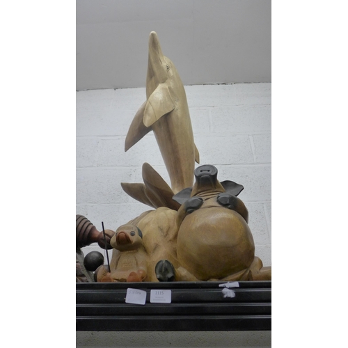 2115 - A large wooden sculpture of a dolphin and a quantity of other wooden models and sculptures including... 