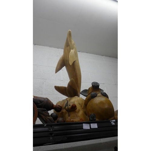 2115 - A large wooden sculpture of a dolphin and a quantity of other wooden models and sculptures including... 