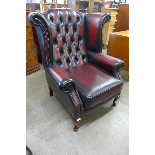 1 - An oxblood red leather Chesterfield wingback armchair