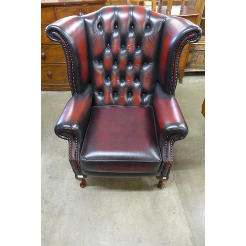 1 - An oxblood red leather Chesterfield wingback armchair