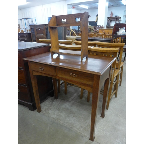 115 - An Arts and Crafts oak two drawer side table and a book rack