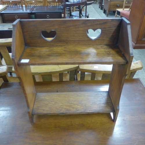 115 - An Arts and Crafts oak two drawer side table and a book rack