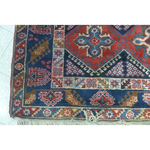 174 - A Turkish red ground woollen rug, 284 x 205cms