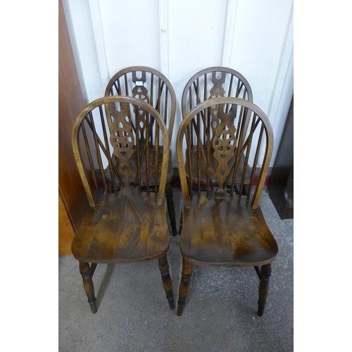 20 - A set of four beech wheelback Windsor kitchen chairs