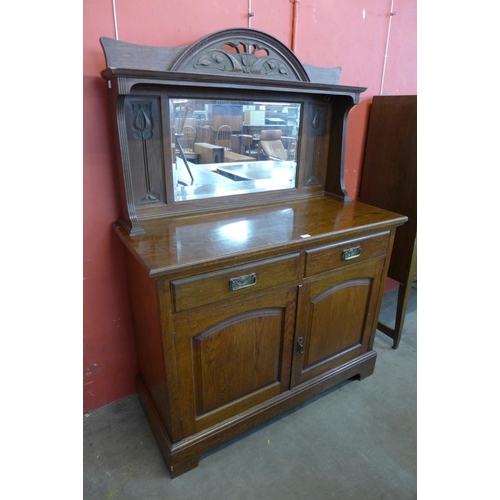 24 - An Arts and Crafts carved oak mirrorback sideboard