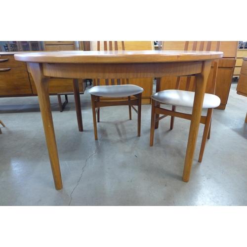 64 - A McIntosh teak circular extending dining table and four teak dining chairs