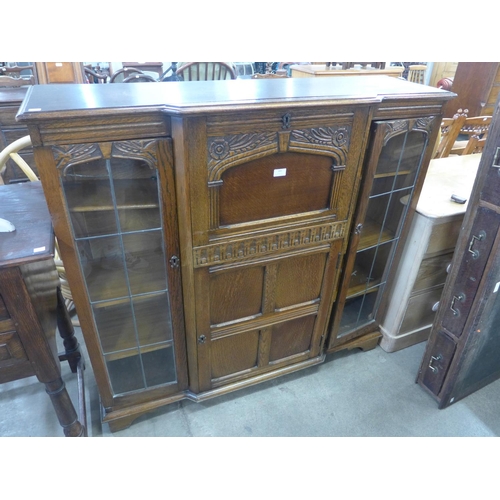 151 - A carved oak side by side bureau bookcase (locked and without key)