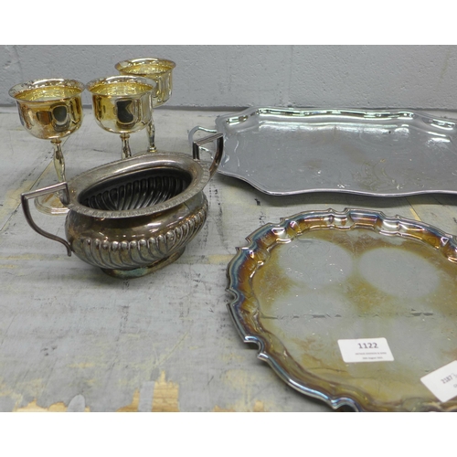 1122 - A collection of plated ware including trays, goblets, a three piece tea service and a pewter hip fla... 