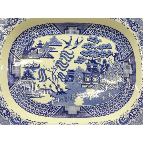 604 - A large Willow pattern serving plate, chips to the rim