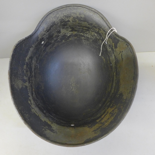 717 - A German WWII M35 helmet shell with post war paint and decal