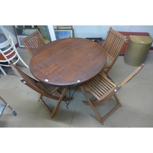 239 - A teak circular folding garden table and four chairs