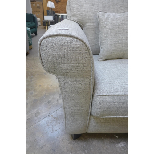 1409 - An oatmeal textured weave upholstered 3.5 seater sofa