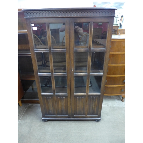 105 - A carved oak linenfold two door bookcase