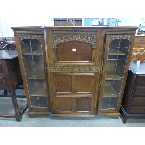 151 - A carved oak side by side bureau bookcase (locked and without key)