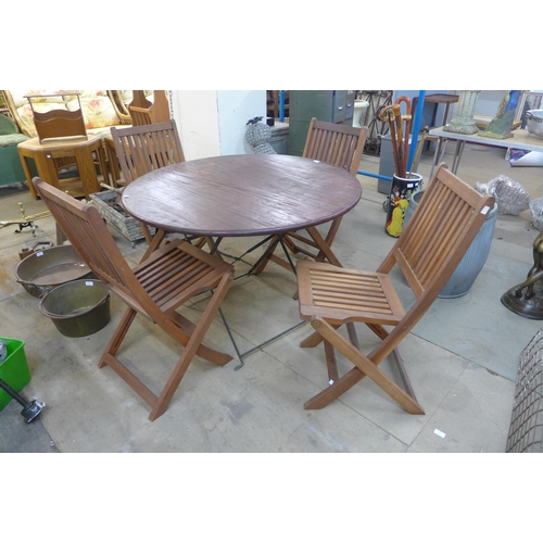 239 - A teak circular folding garden table and four chairs