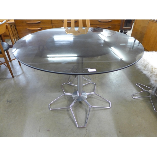 27 - A 1970s chrome and smoked glass circular dining table and four Perspex chairs