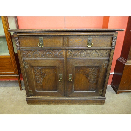 98 - A German Jugenstil carved oak sideboard with marble brushing slide