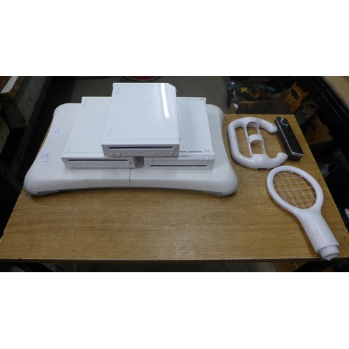 2121 - A Wii bundle- 3 consoles with remotes and charges and a Wii board