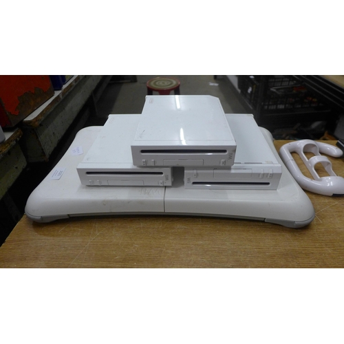 2121 - A Wii bundle- 3 consoles with remotes and charges and a Wii board