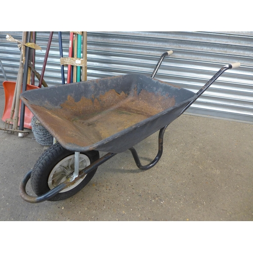 2289 - A metal gardener's wheelbarrow with a bundle of garden tools and barbed wire