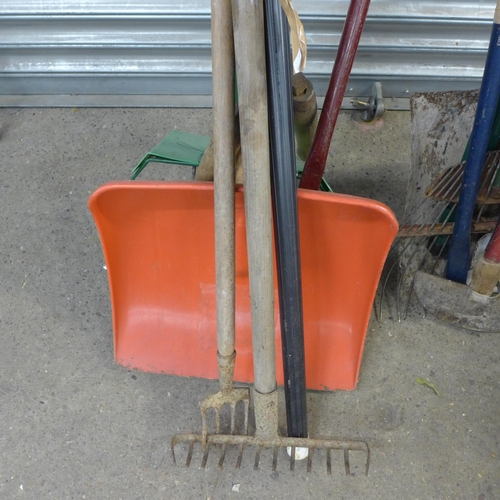 2289 - A metal gardener's wheelbarrow with a bundle of garden tools and barbed wire