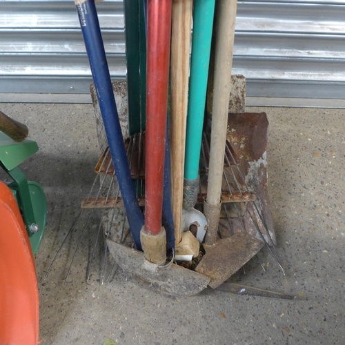 2289 - A metal gardener's wheelbarrow with a bundle of garden tools and barbed wire