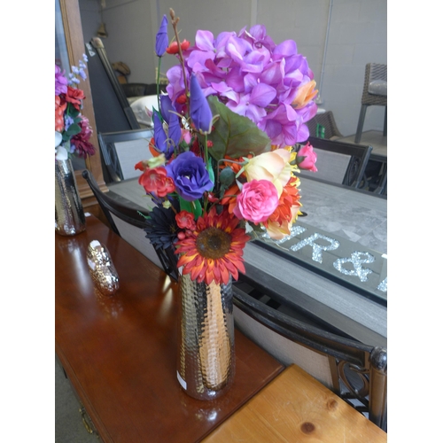 1594 - An arrangement of flowers in tall silver vase