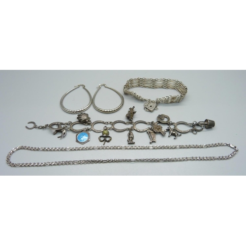 1008 - A silver horse shoe charm bracelet, a silver gate bracelet, a pair of silver earrings and a silver c... 