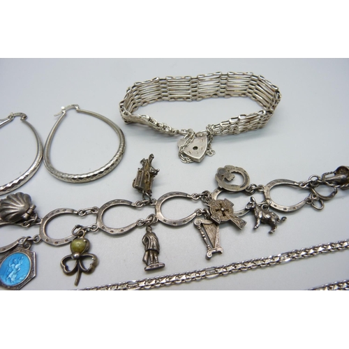 1008 - A silver horse shoe charm bracelet, a silver gate bracelet, a pair of silver earrings and a silver c... 