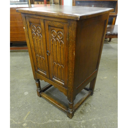 128 - A small carved oak two door cupboard