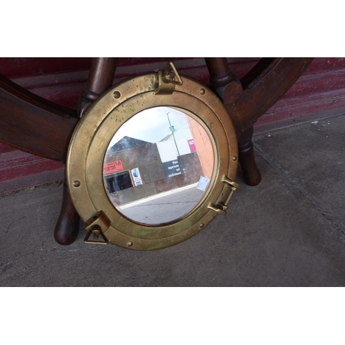 336 - A brass porthole mirror and a stained pine ships wheel