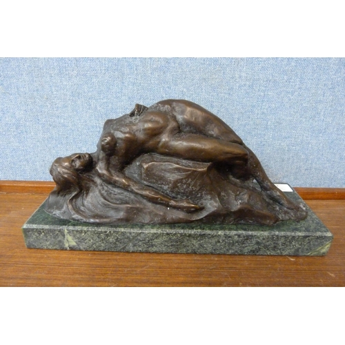 352 - An Art Deco style bronze figure of a reclining female nude on a rock, on black marble socle