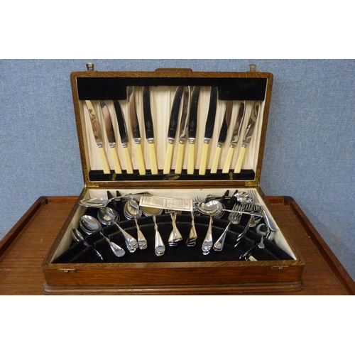 353 - An oak cased canteen of stainless steel and faux ivory cutlery