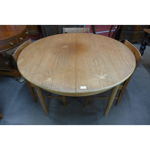 37 - A teak circular extending dining table and four chairs