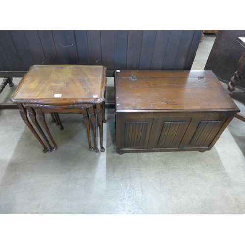 599 - A carved oak linenfold blanket box and a walnut nest of tables