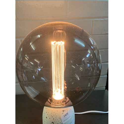 1409 - A terrazzo base table lamp with a large smoked glass anti-glare bulb featuring a decorative internal... 