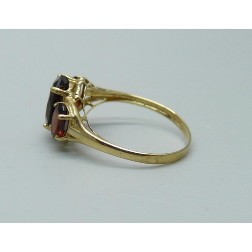 1015 - A 9ct gold and red stone ring, 1.9g, O