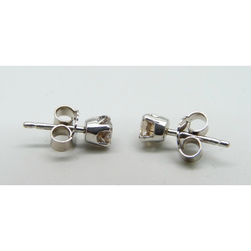 1037 - A pair of hallmarked 18ct white gold and diamond stud earrings, total diamond weight 0.64cts