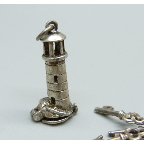 1038 - Ten silver charms and a padlock fastener, all test as silver