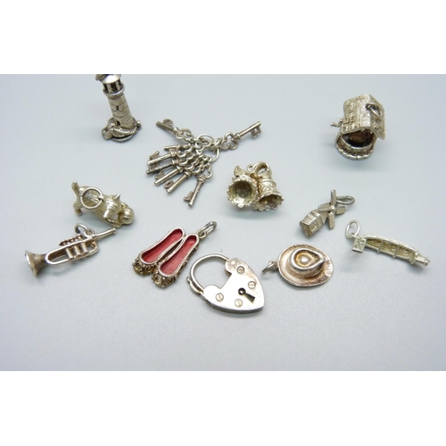 1038 - Ten silver charms and a padlock fastener, all test as silver