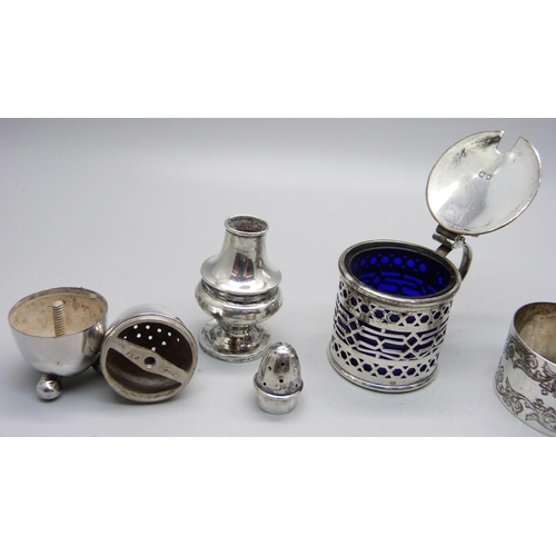 817 - A pierced silver mustard with liner, Chester 1913, a Victorian silver napkin ring and two silver pep... 